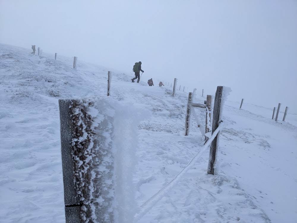 Zwei Personen gehen einen verschneiten Hügel im Schnee hinauf