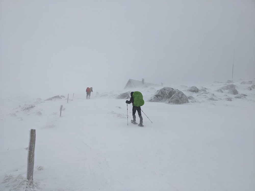 Ein paar Leute fahren Skier einen schneebedeckten Hang hinunter