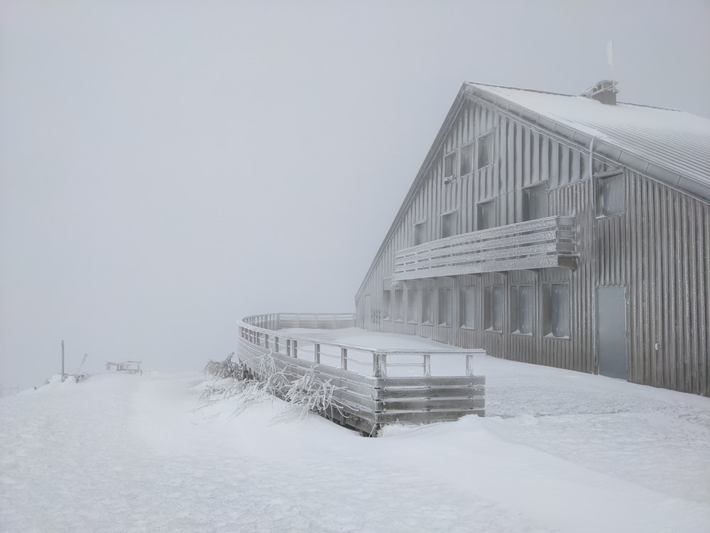 a barn in the middle of a snowy field