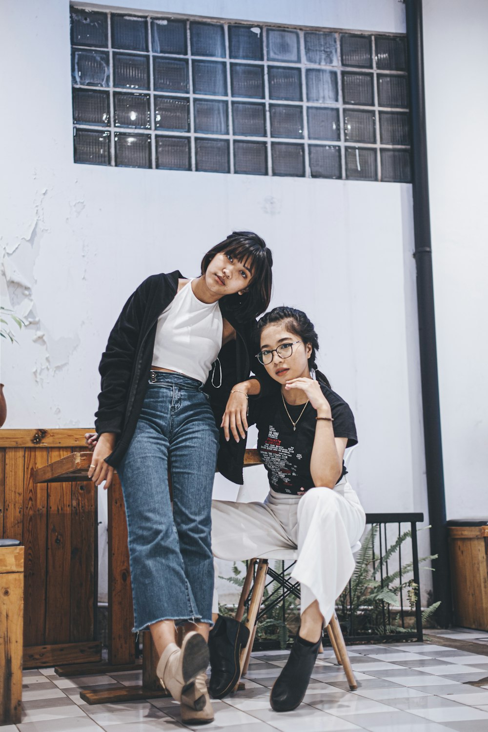 two women pose for a picture in front of a building