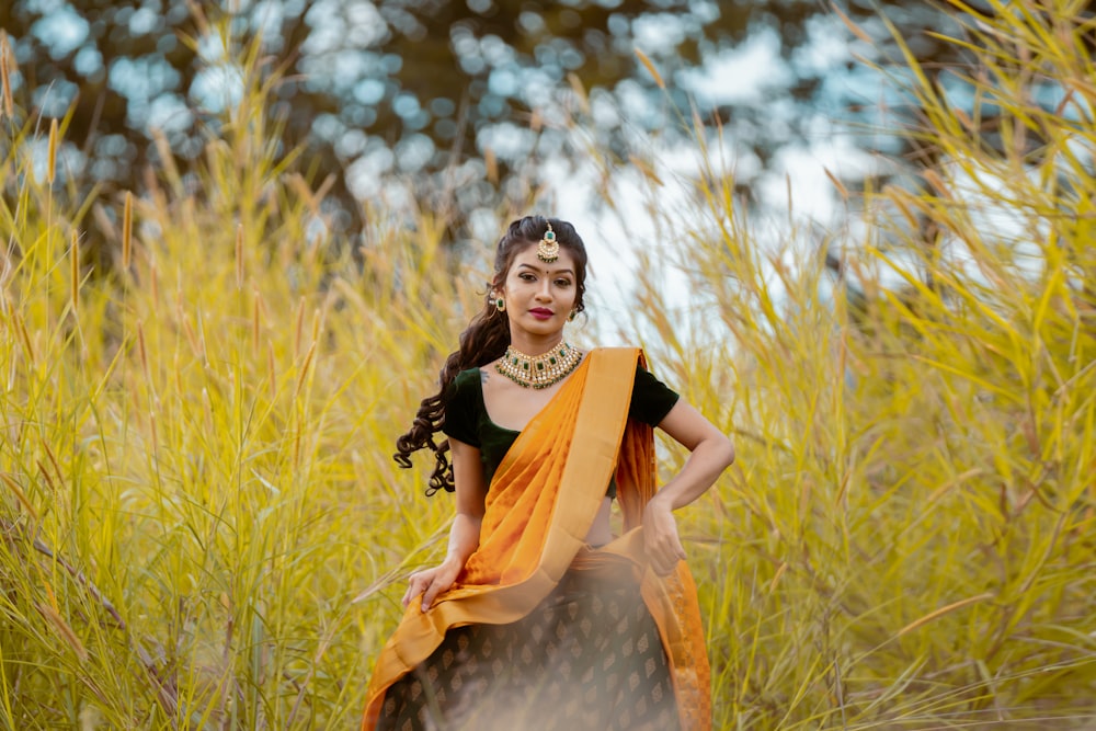 a woman standing in a field of tall grass