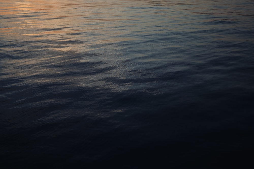 a large body of water with a sunset in the background