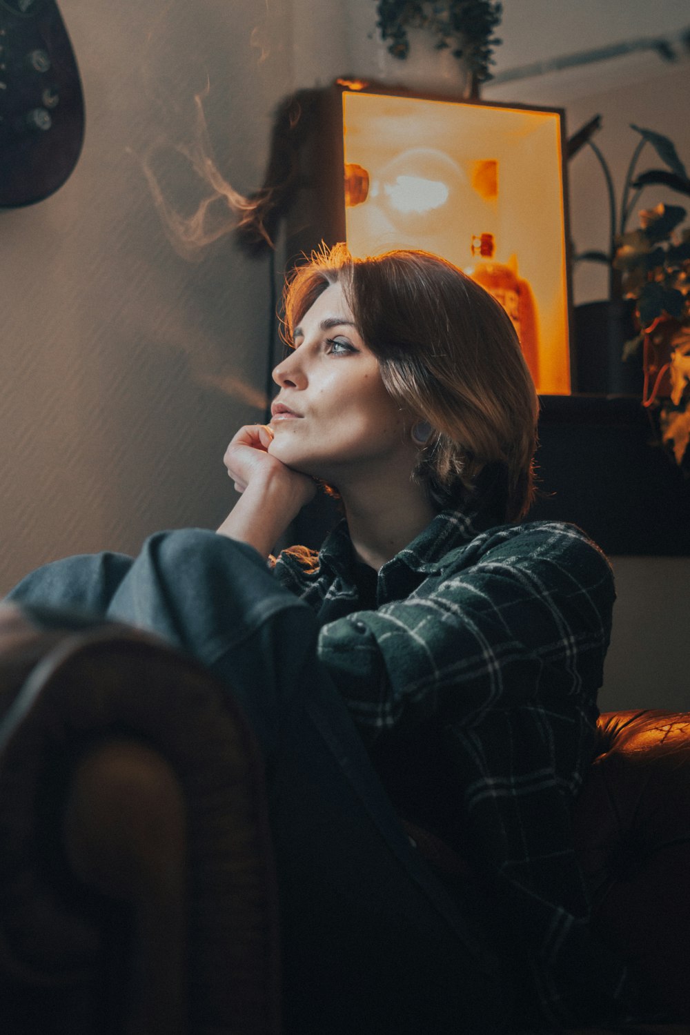 a woman sitting in a chair with her hand on her chin