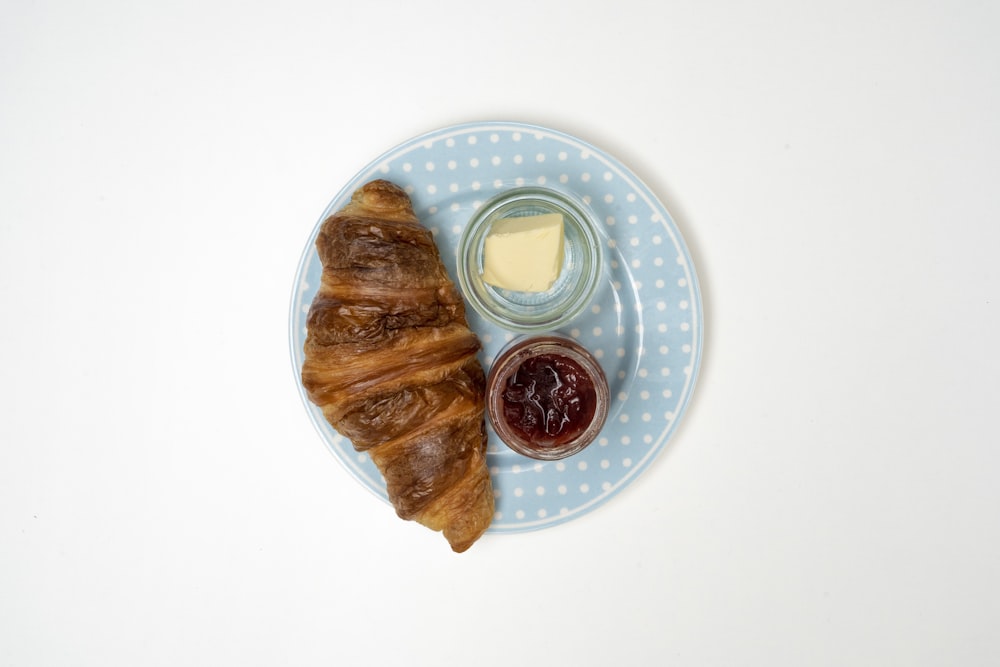 a croissant and jam on a plate