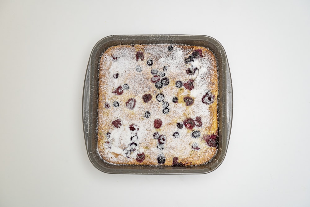 a pan filled with a cake covered in berries