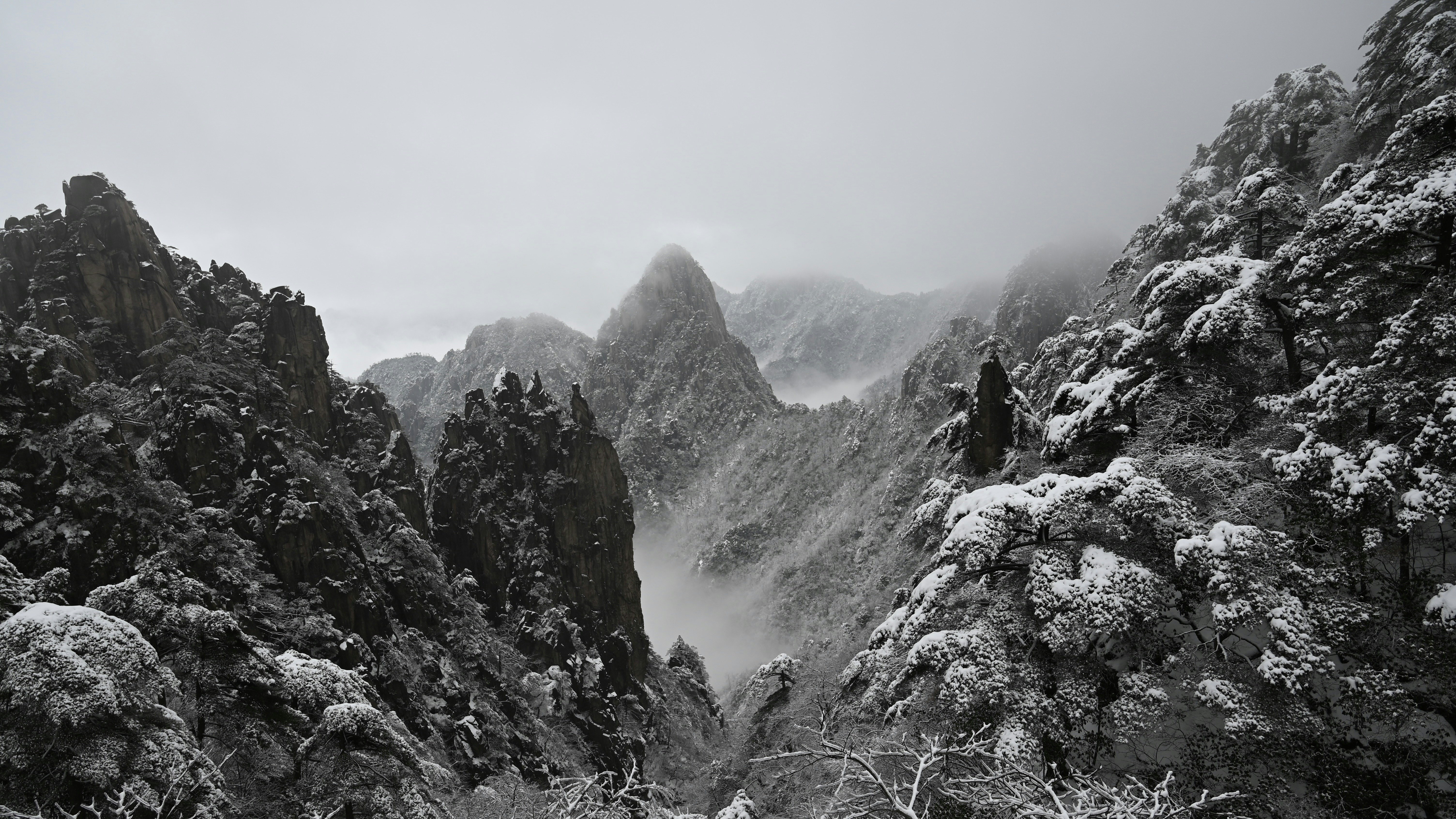 a black and white photo of snow covered mountains