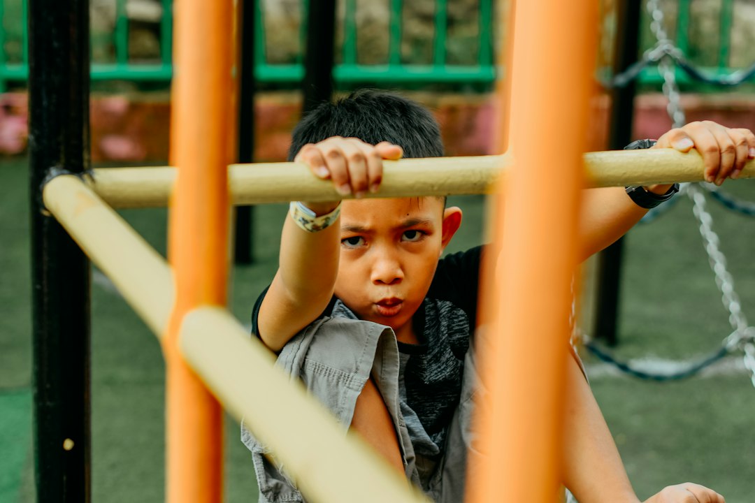 a young boy is playing on a playground