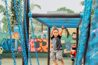 a little boy standing on a slide at a park
