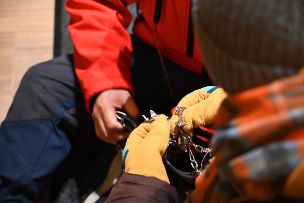 a person in a red jacket and a pair of gloves