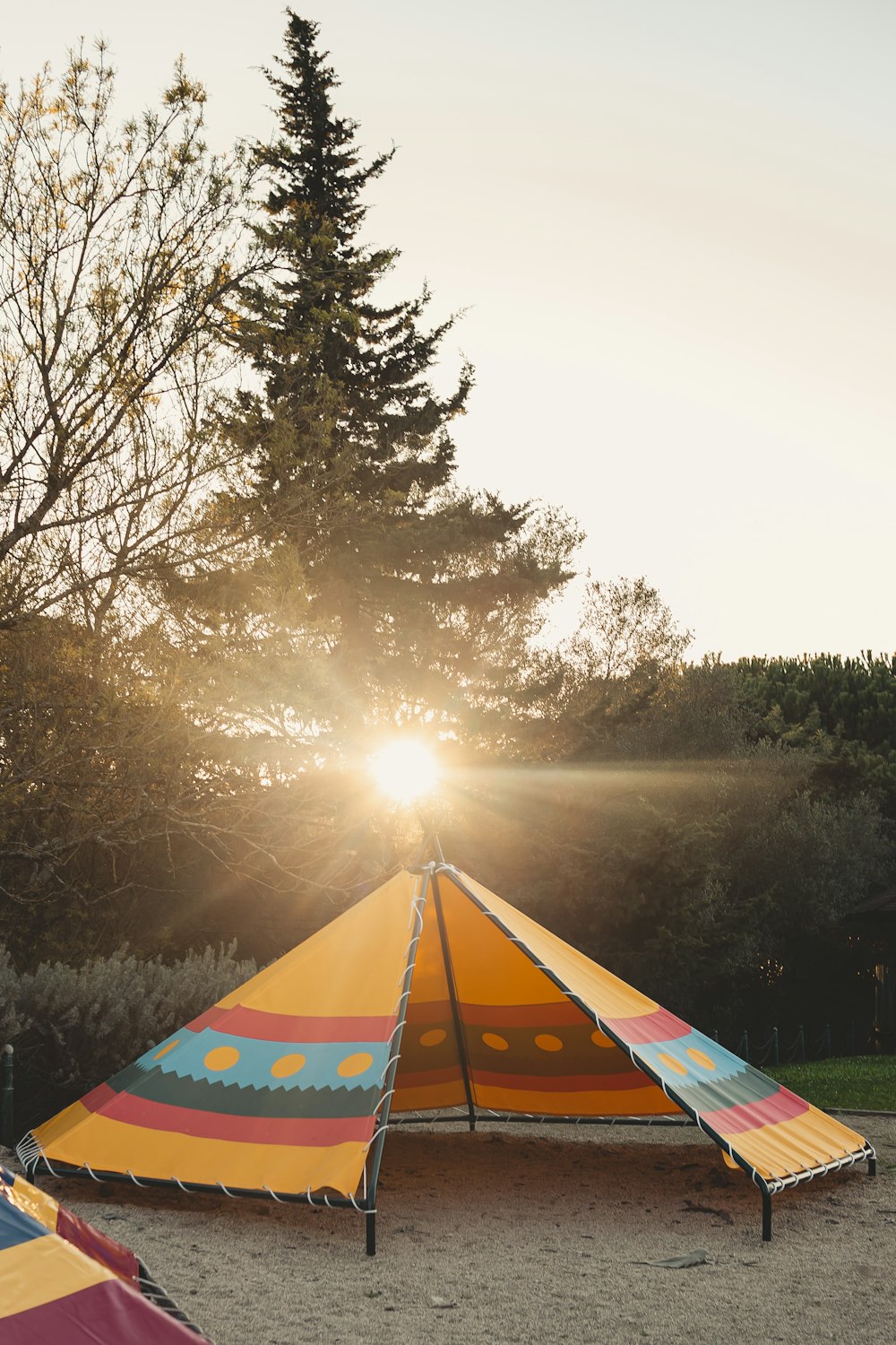 a colorful tent sitting on top of a sandy beach