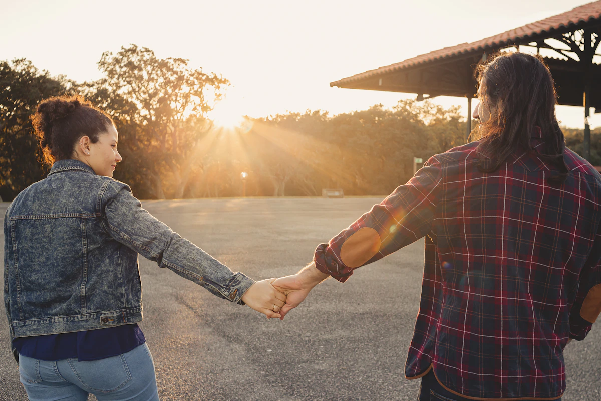A couple holding hands beside a peaceful lake