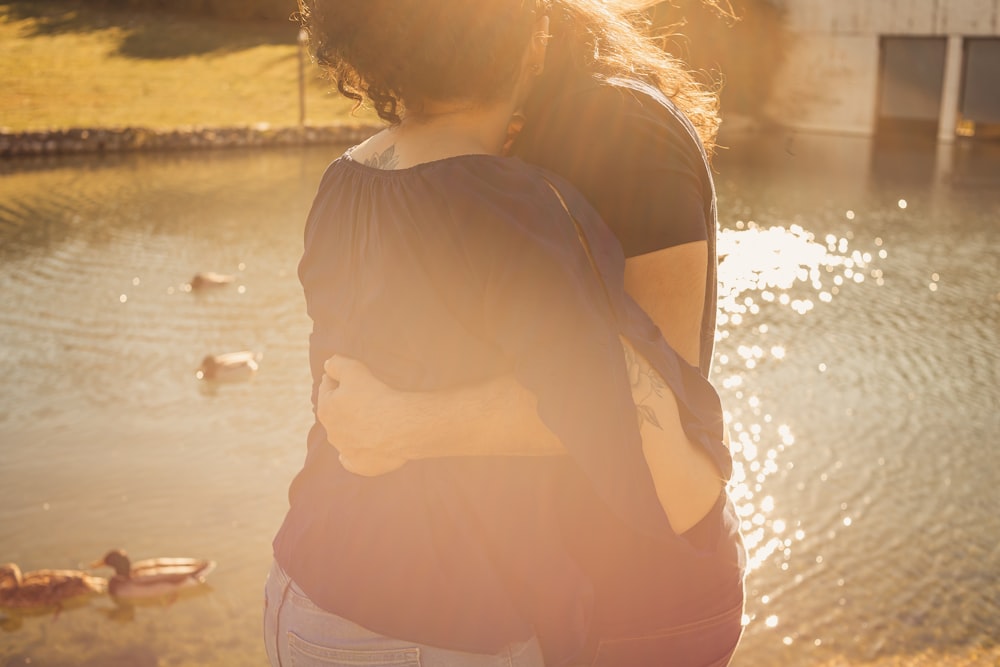 a woman standing in front of a body of water