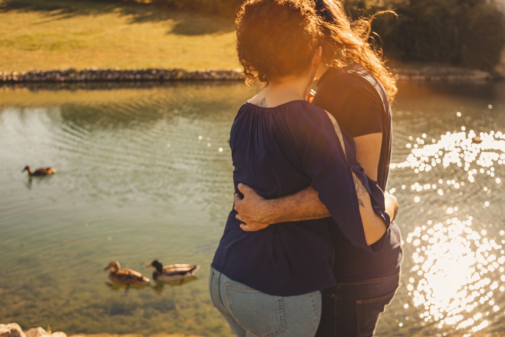 a man and a woman standing next to each other near a body of water