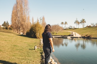 a man standing next to a body of water