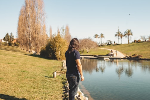 a man standing next to a body of water