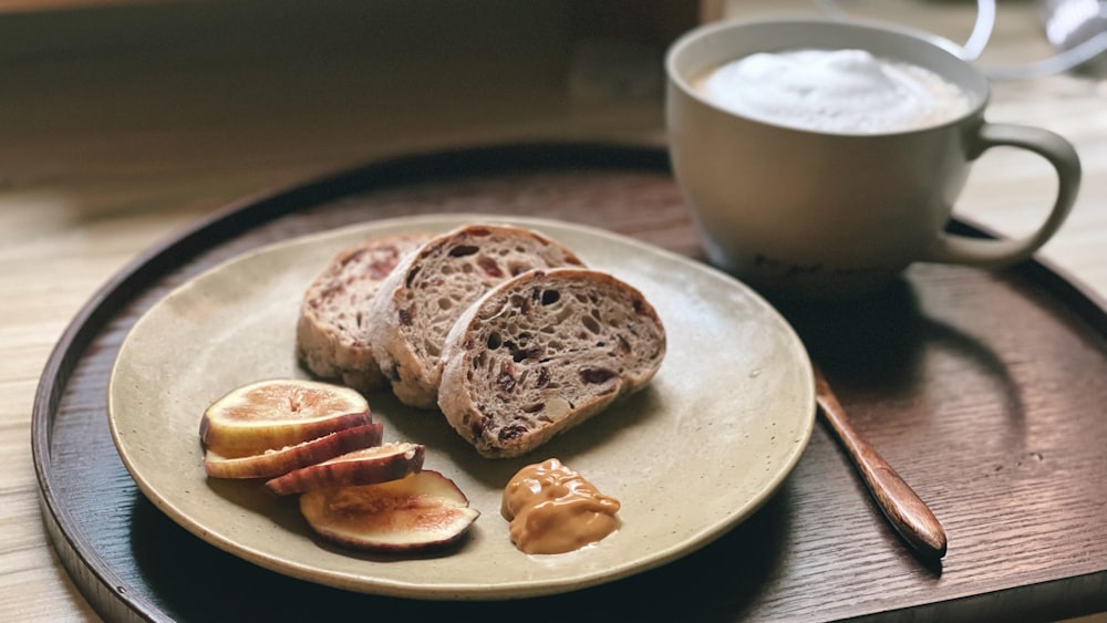 un piatto bianco sormontato da fette di pane accanto a una tazza di caffè