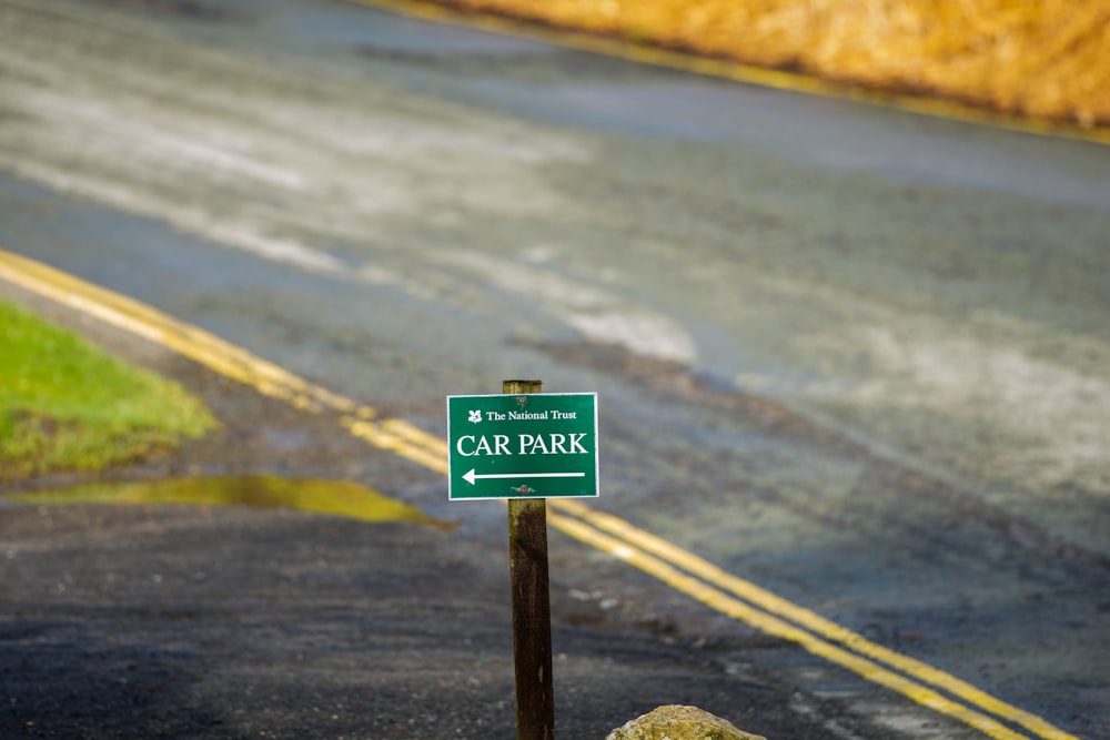 a car park sign sitting on the side of a road