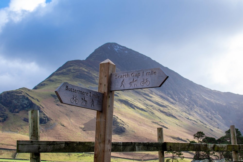 a wooden fence with two signs pointing in opposite directions