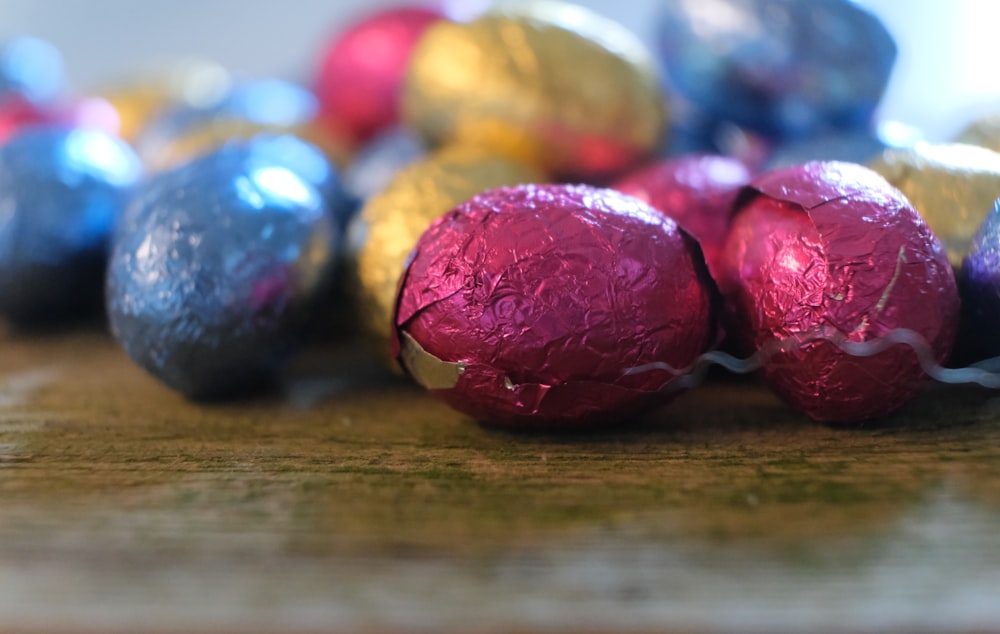 a bunch of chocolate eggs sitting on top of a wooden table