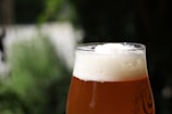 a glass of beer sitting on top of a table