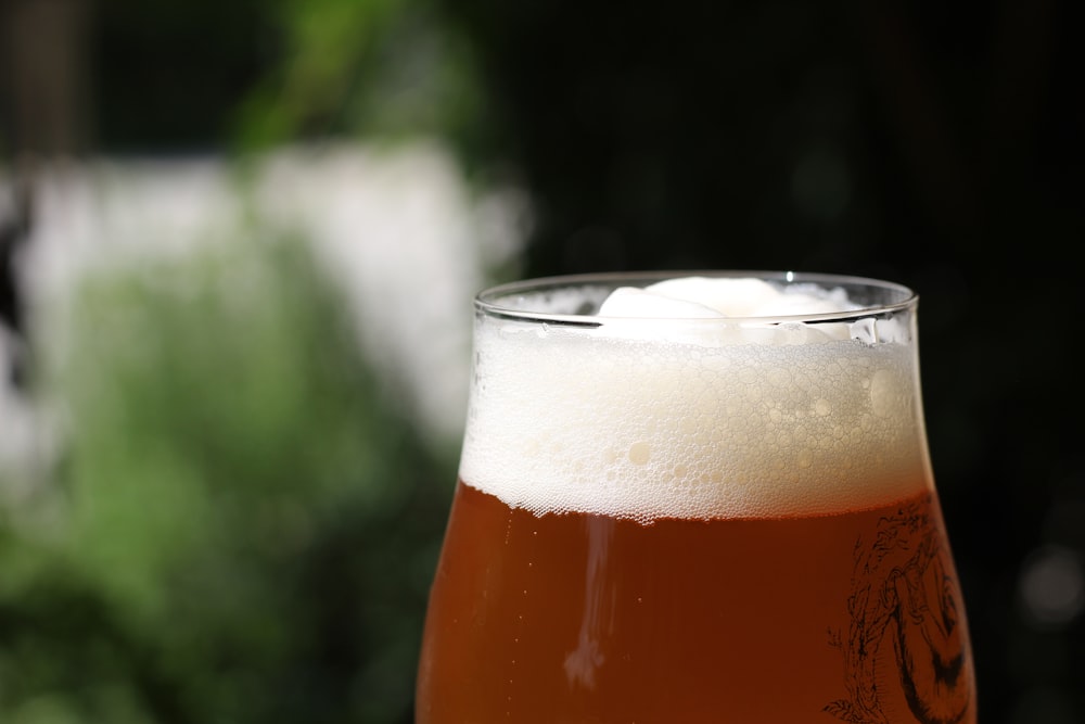 a glass of beer sitting on top of a table