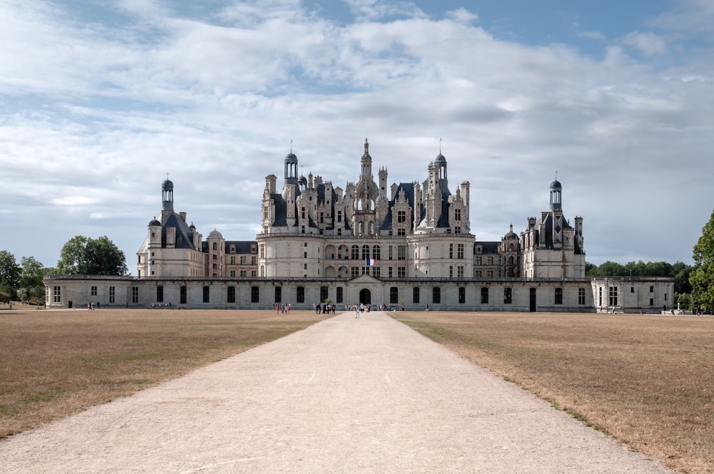 a large castle with a long driveway leading to it