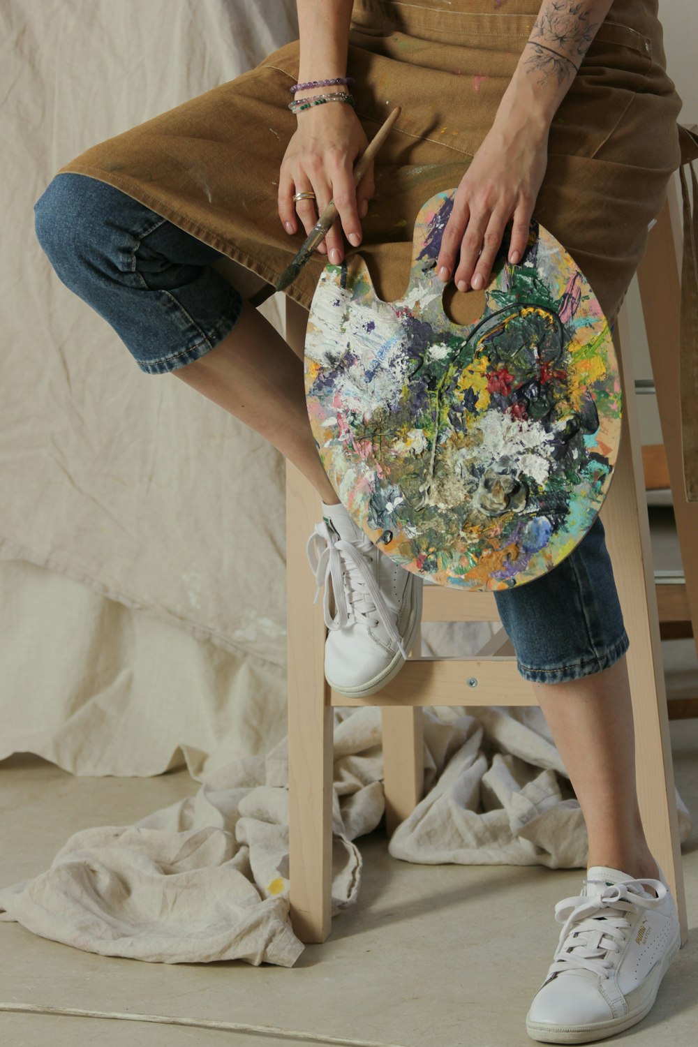 a woman sitting on a chair holding a painting