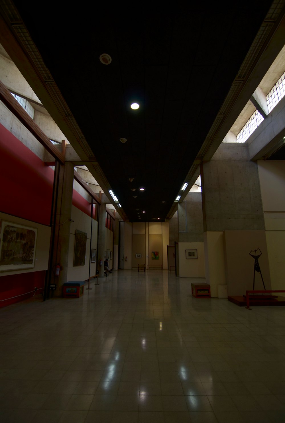 a dimly lit hallway in a building with large windows