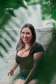 a woman sitting on the ground in a black top