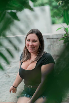 a woman sitting on the ground in a black top