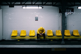 a person sitting on a bench in a subway