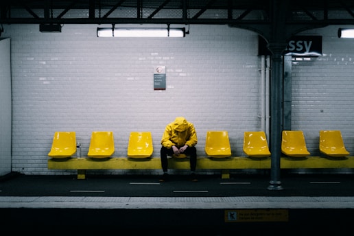 a person sitting on a bench in a subway