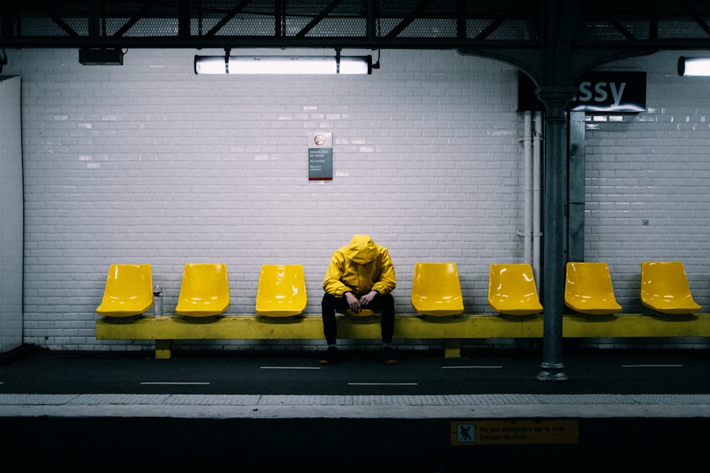 a person sitting on a bench in a subway