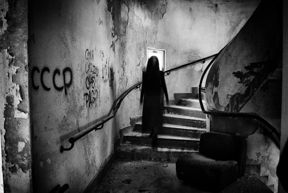 a woman with long hair walking down a set of stairs