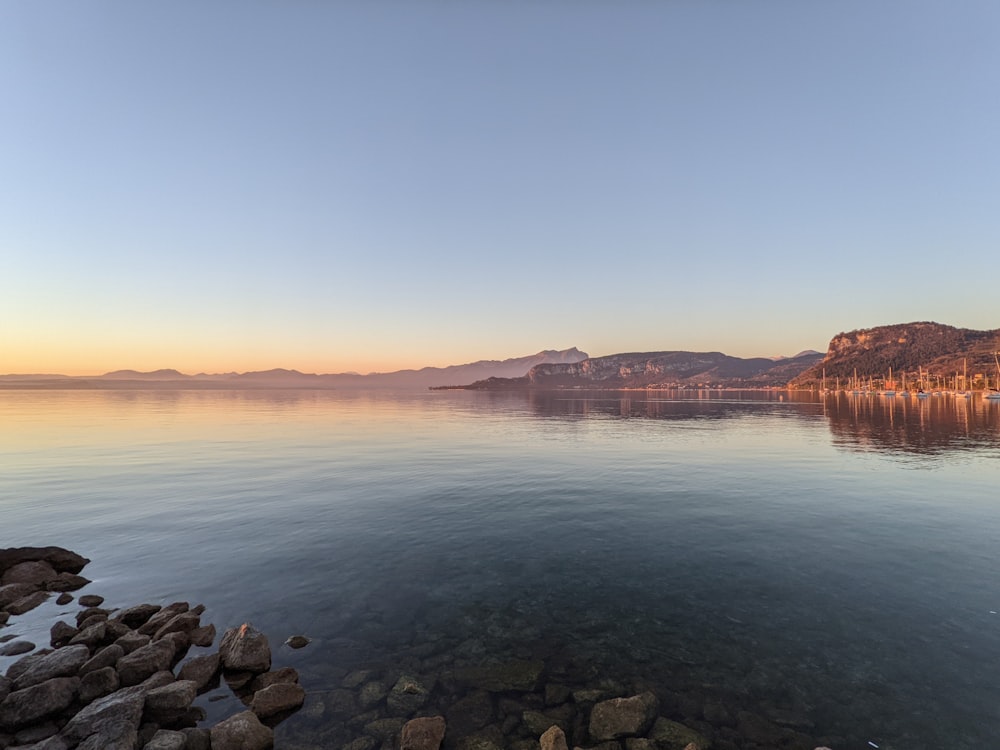 a large body of water with a mountain in the background