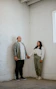 Smiling middle-aged couple admiring their freshly renovated living room with bright natural light.