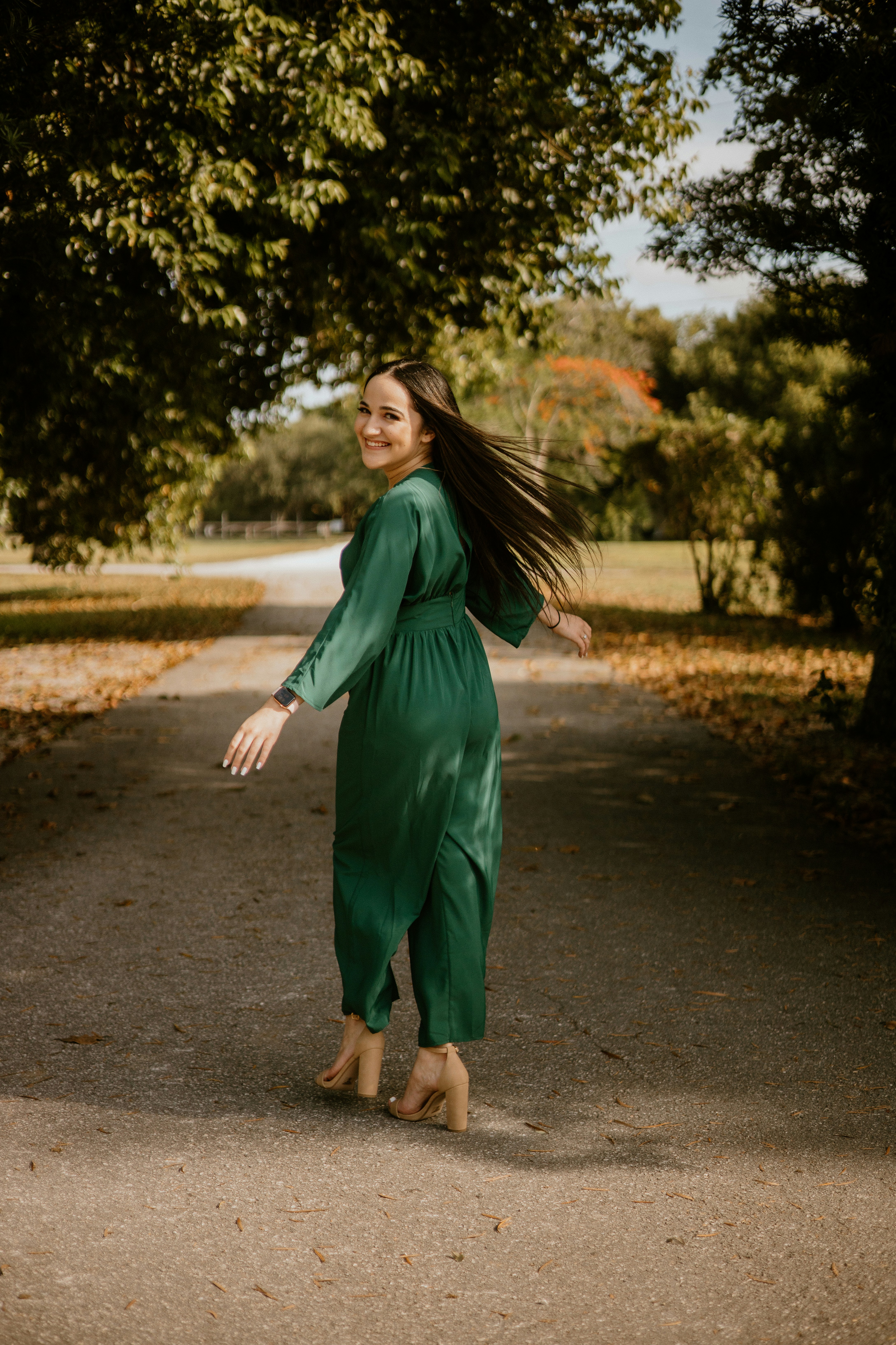 a woman in a green dress walking down a road
