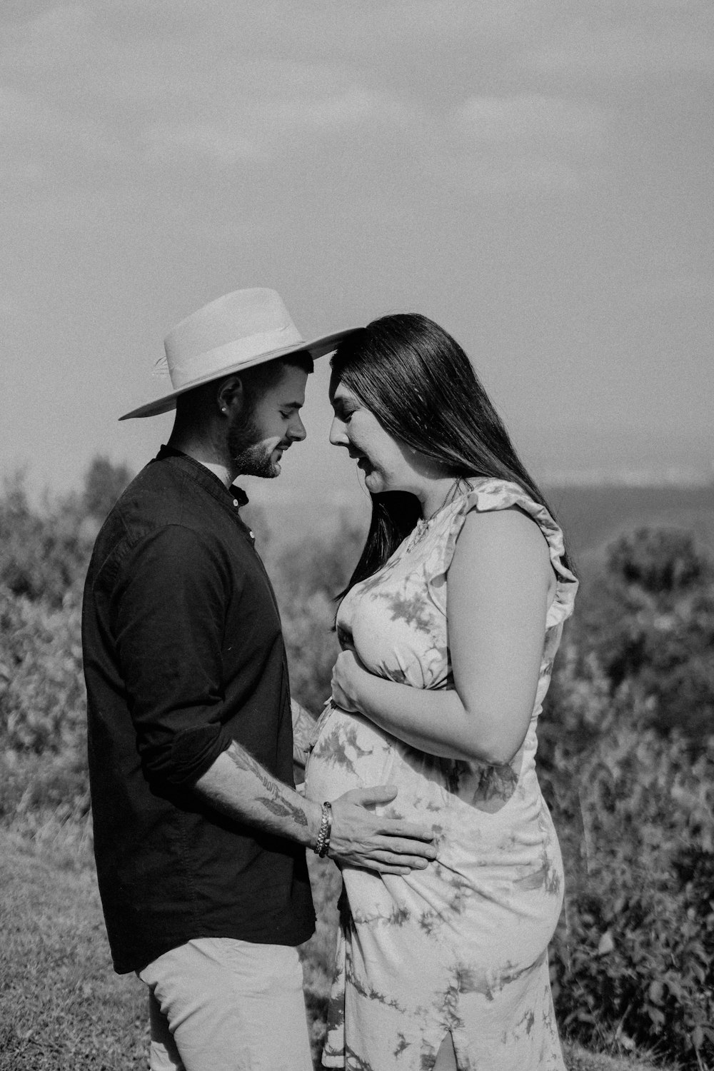 a man and woman standing next to each other in a field