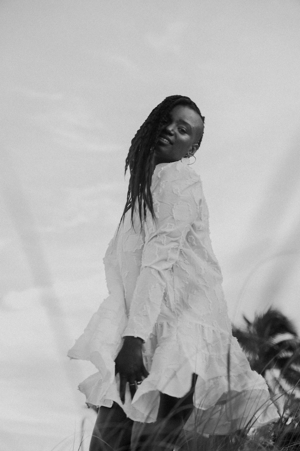 Une femme en robe blanche debout dans un champ