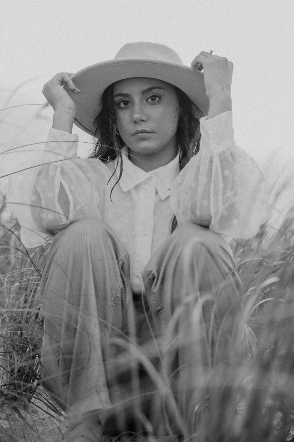 a black and white photo of a woman wearing a hat