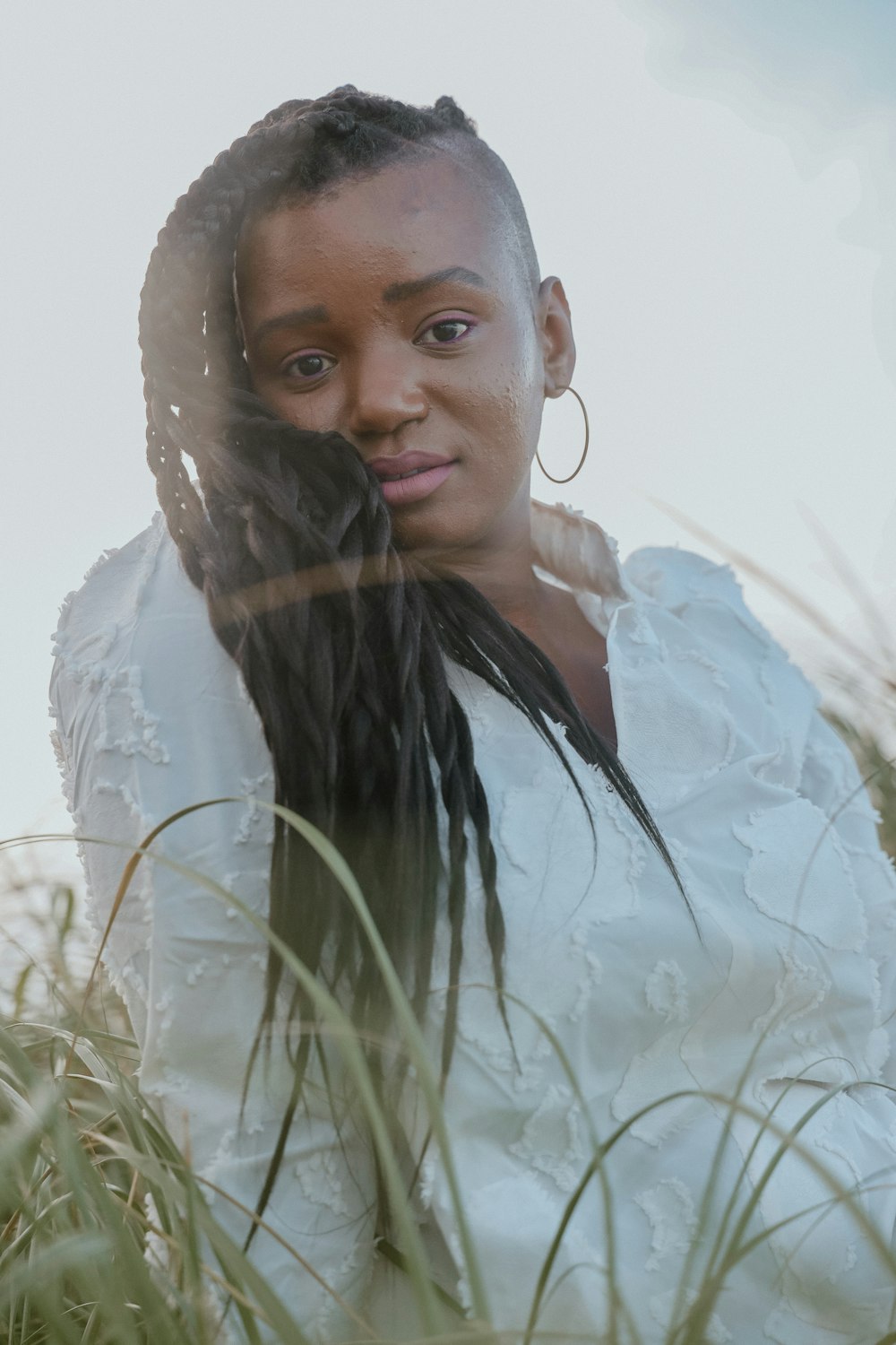 a woman in a white dress standing in tall grass