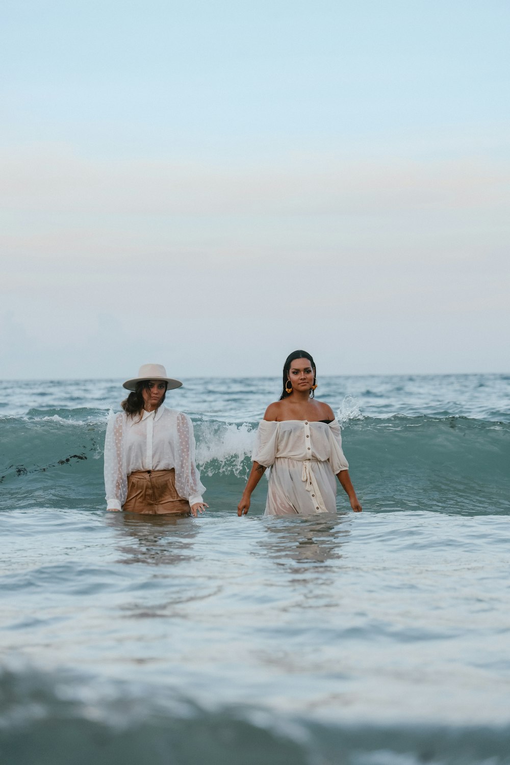 two women walking into the ocean together
