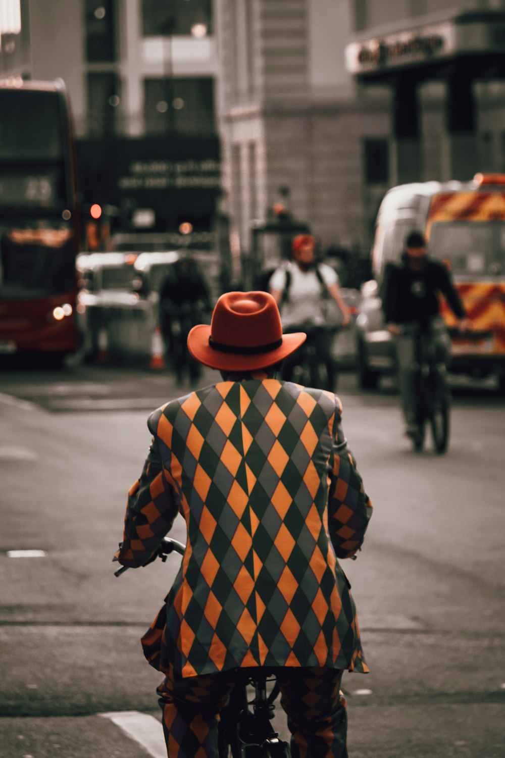 a man in a clown suit riding a bike down a street