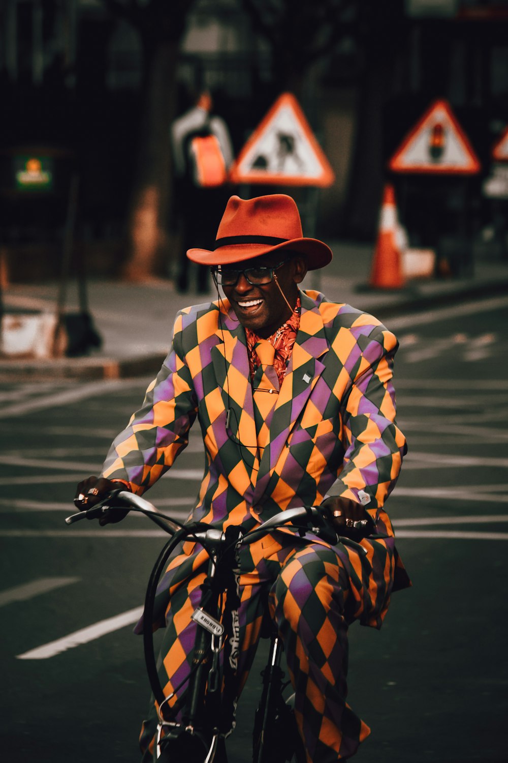 a man in a clown suit riding a bicycle