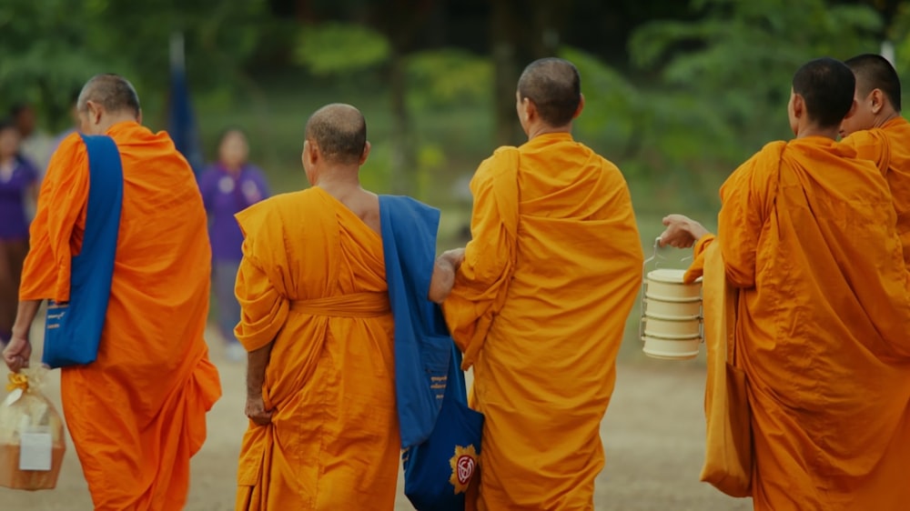 a group of monks walking down a dirt road