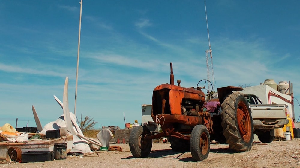 an orange tractor parked next to a white truck