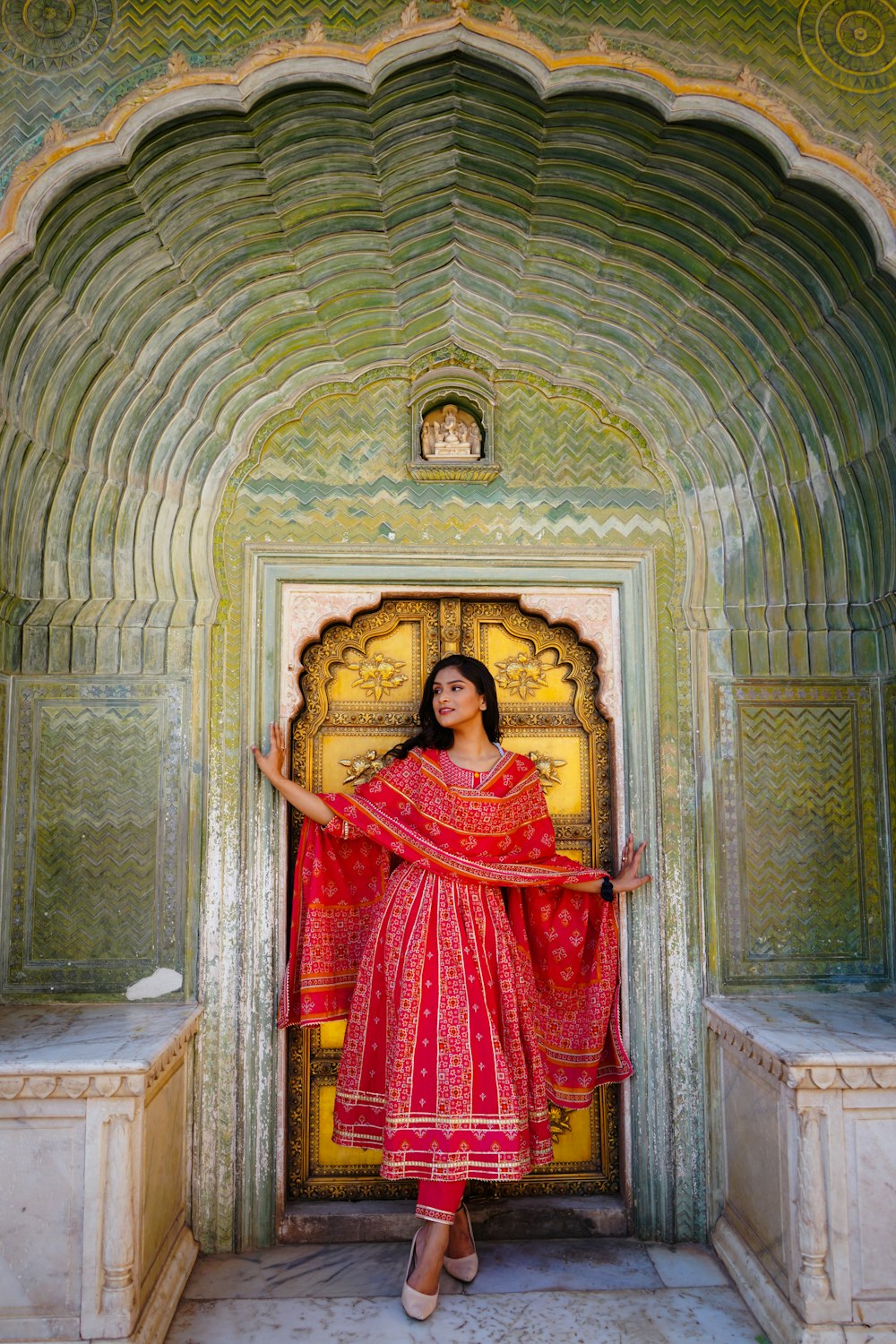 a woman in a red dress standing in a doorway