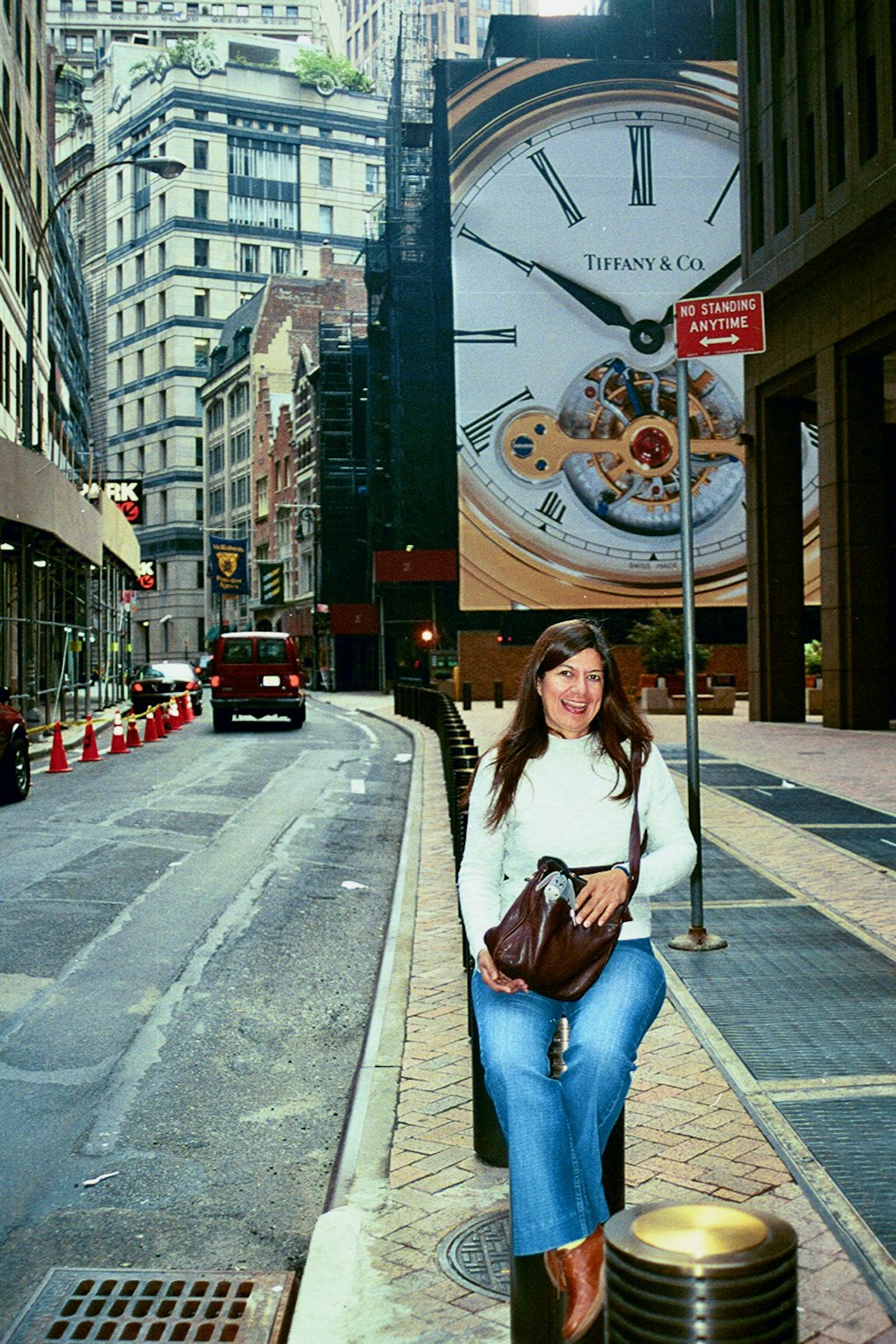 a woman sitting on a pole in front of a clock