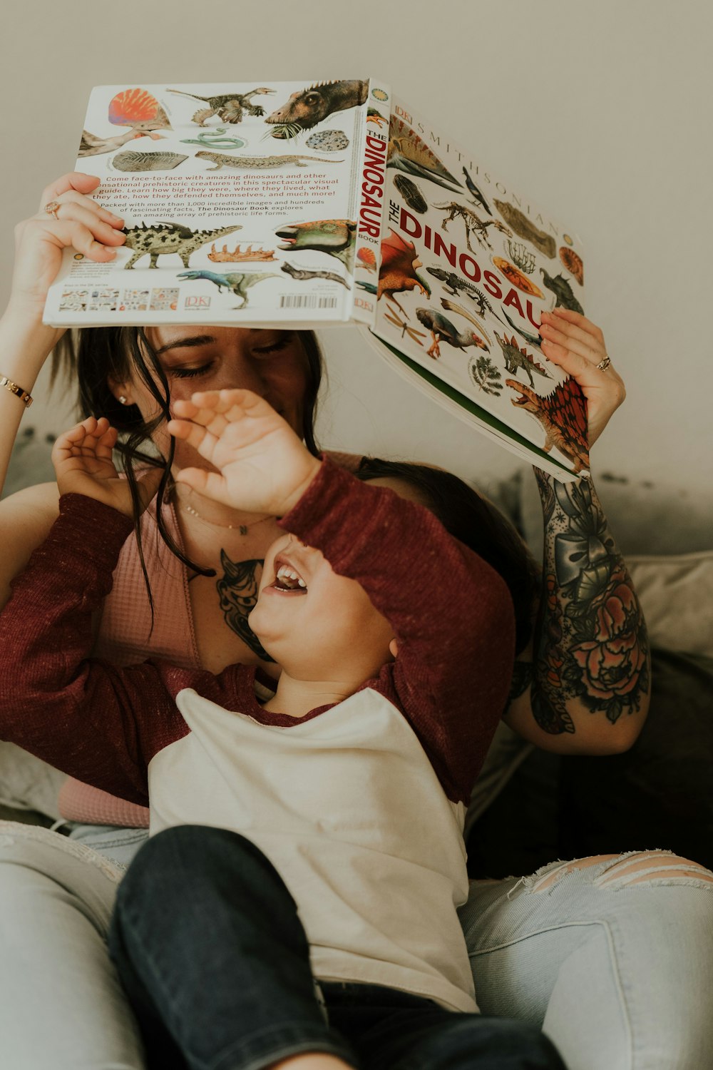 a woman is holding a book over her head