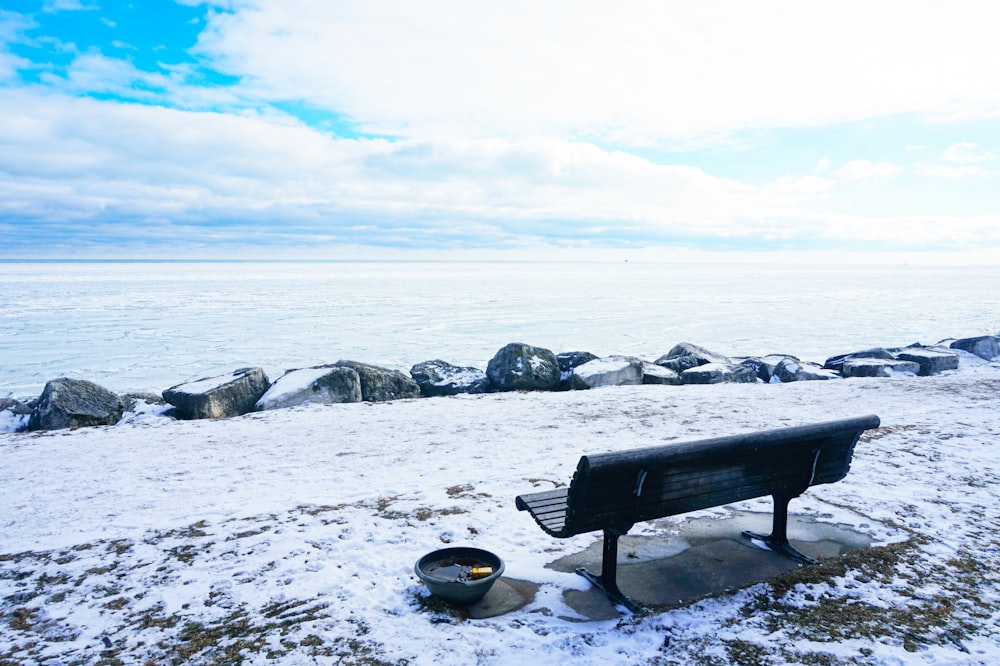 a bench sitting on top of a snow covered field